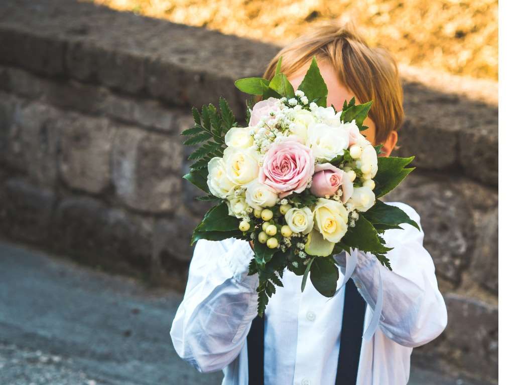 Un enfant qui jouet avec le bouquet de la mariée